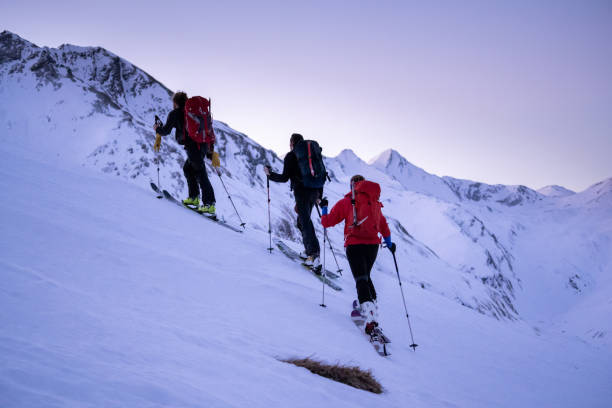 backcountry-skifahrer steigen berg auf - telemark skiing stock-fotos und bilder
