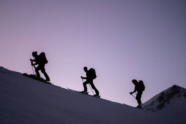 Backcountry skiers ascend mountain ridge