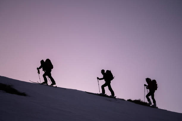 los esquiadores de fondo ascienden a la cresta de la montaña - determination telemark skiing exploration winter fotografías e imágenes de stock