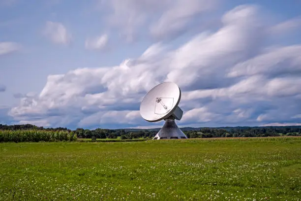 Photo of Huge parabolic antenna in the midst of a beautiful landscape