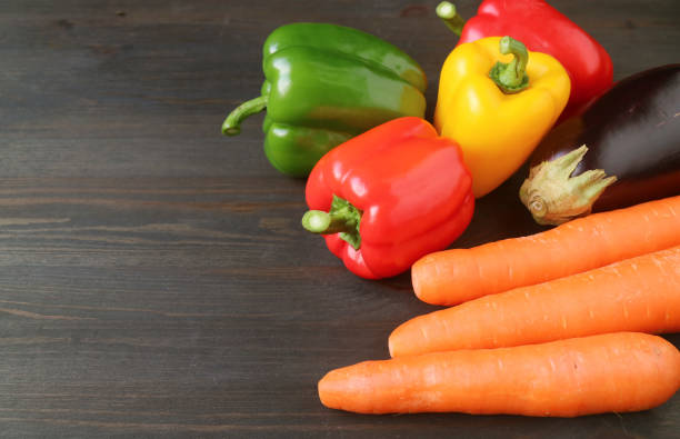 istock Closeup colorful fresh vegetables on dark brown wooden table with copy space 1218054893