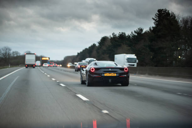 M1 Motorway, United Kingdom - March 17, 2020: Ferrari 488 Black driving on the M1 Motorway. People in the car are enjoying the ride.