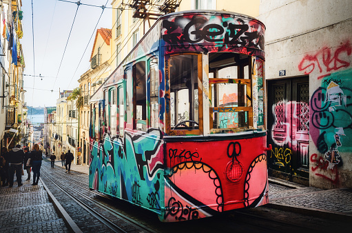 Lisbon, Portugal - May 31, 2022: In the streets of Lisbon by day. Historic tram in everyday life.