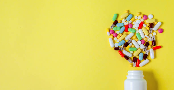 istock Colorful Assorted Pharmaceutical Pills, Tablets, Capsules and Bottle on Yellow Background. Banner 1218057048