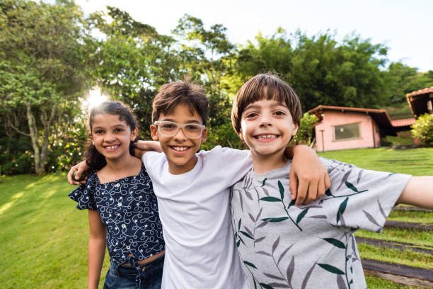 istock Group of children hugging on home lawn 1218065499