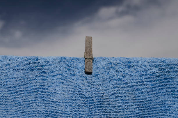 Clothes peg on a blue towel and washing line against the dark sky