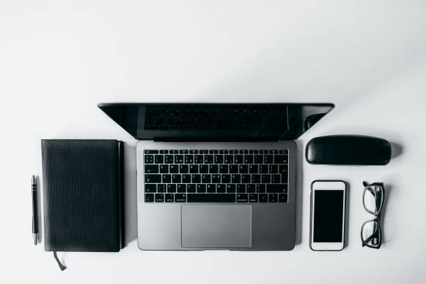 istock Freelancer workplace on a white background with place for text. Top view. Laptop, glasses, notebook, pen and phone 1218068118