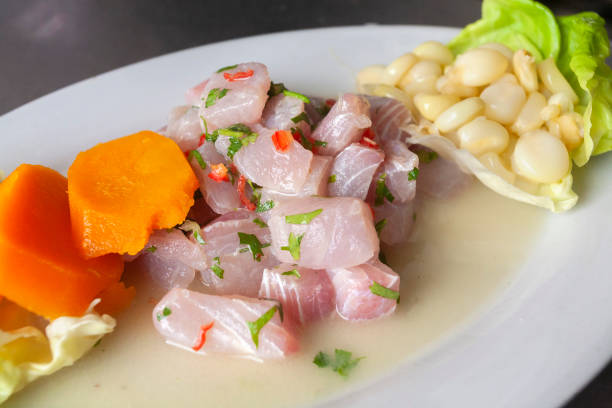 Peruvian food or fish cebiche Peruvian seafood: fish cebiche with onion, chili, sweet corn and sweet potato decorated with a green lime slice seviche photos stock pictures, royalty-free photos & images
