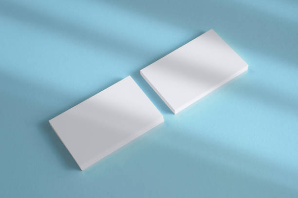 istock 2 blank business cards stack on textured blue background and shadow overlay as template for design, logo, embossing presentation, promotion, branding etc. 1218074661