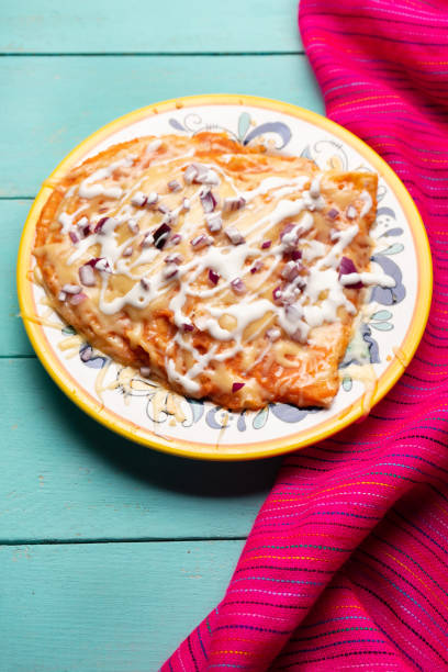 istock Mexican red enchiladas with melted cheese on turquoise background 1218079647