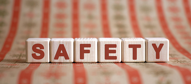 SAFETY- financial business concept. Wooden cubes on a color table.