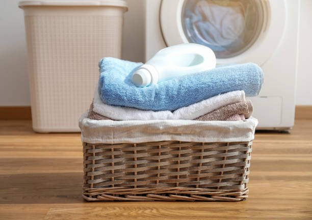 Wicker laundry basket with clean bath towels Wicker laundry basket with folded bath towels and washing gel fabric softener photos stock pictures, royalty-free photos & images