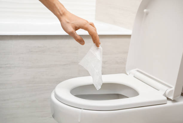 istock Hand throwing out toilet sheet in bowl 1218082368