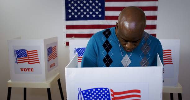 istock Front view African American man voting in booth at polling station 1218082548