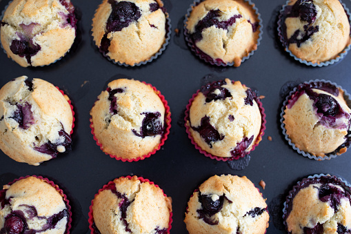 Directly above shot of baked blueberry muffin in tray.  Close-up of blueberry muffins in baking dish.