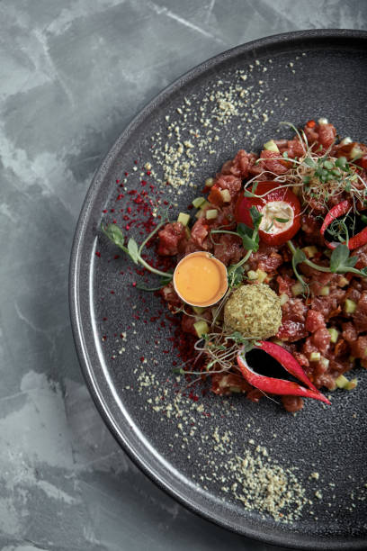 istock Beef tartare with egg yolk on a gray surface, top view, close-up 1218084877
