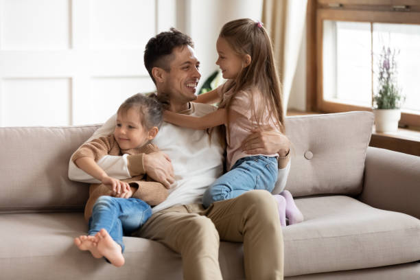 istock Smiling young father playing with small cute kids daughters. 1218085173