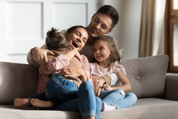 Happy family having fun, sitting together on comfortable couch.