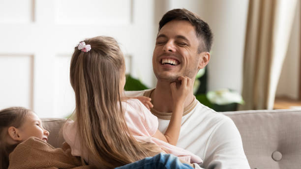 istock Laughing young father having fun with happy playful little daughters. 1218085244