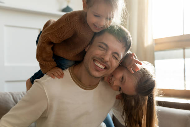 istock Playful little kids siblings having fun with joyful dad. 1218085249