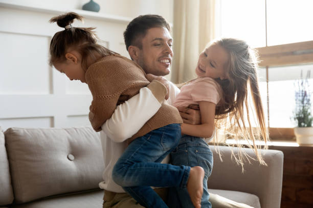 istock Excited young father holding two playful kids siblings. 1218085259