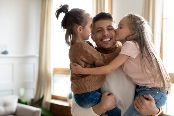 istock Cheerful daddy holding adorable little children siblings. 1218085261