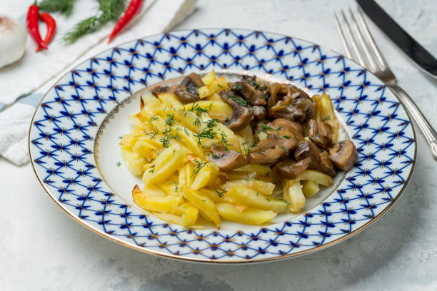 istock Fried potatoes with mushrooms on grey concrete table 1218085314