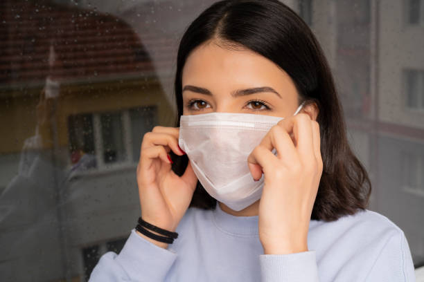 Young woman wearing a mask to protect herself against the coronavirus while going out stock photo
