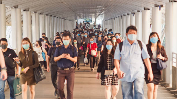 Less crowded Asian people wear face mask walk in pedestrian walkway. Coronavirus disease Covid-19 pandemic outbreak effect on human society Bangkok, Thailand - Apr 7, 2020: Crowded Asian people wear face mask walking in pedestrian walkway. Coronavirus disease Covid-19 pandemic outbreak effect on human, city life, or air pollution concept thai ethnicity stock pictures, royalty-free photos & images