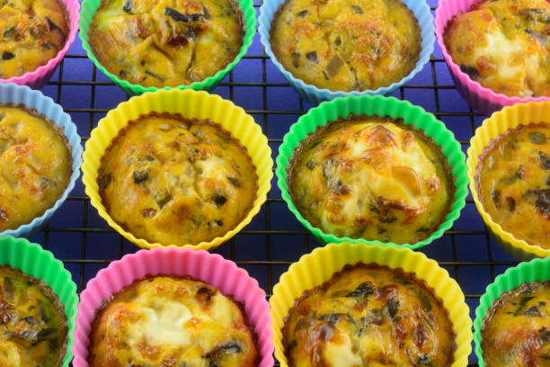 Baked scarmbled egg omelet cups Warm baked scrambled egg cups with chopped mushrooms, bell peppers and onions in silicone muffin cups on cooling rack muffin tin eggs stock pictures, royalty-free photos & images