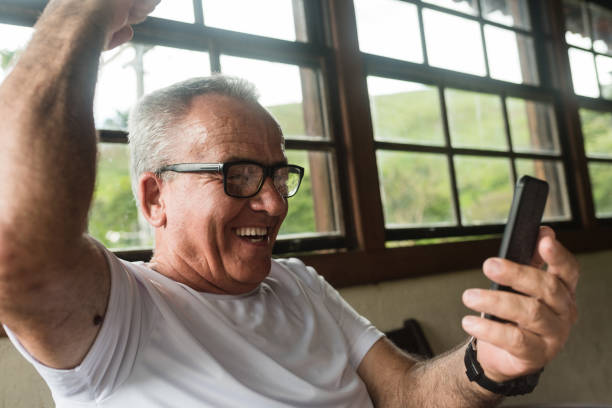istock senior man watching football game on smartphone 1218087608