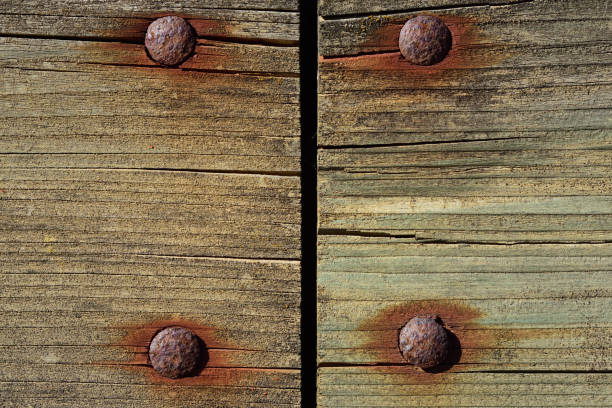 Close-up, background and texture of two weathered raw wood planks that split an image in half and are fastened with rusty nails