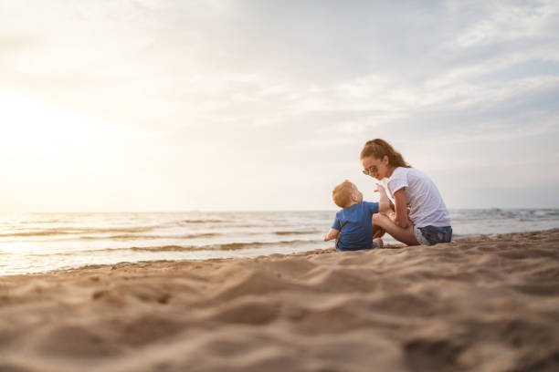 istock Mom and son playing on the beach at sunset 1218090765