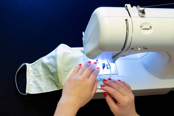 istock A female sewing a homemade face mask on a black table 1218092663