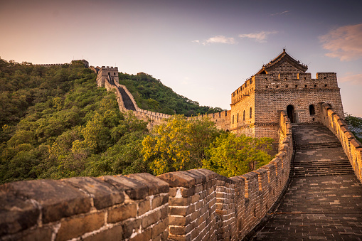 Golden sunlight blankets the Great Wall of China on a moody, cloudy, afternoon near Beijing, China.