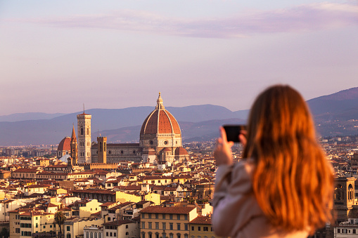 girl making a photo shoot of Florence with the smartphone. Cattedrale di Santa Maria del Fiore