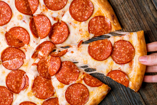 hand takes pizza hand takes pizza pepperoni pizza stock pictures, royalty-free photos & images