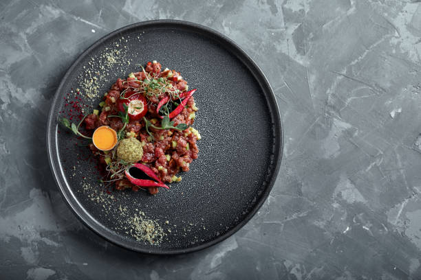 istock Beef tartare with egg yolk on a gray surface, top view, close-up copy space 1218107921