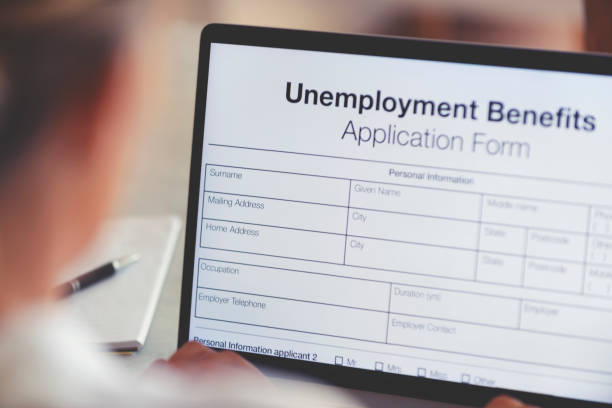 woman filling out an online unemployment benefits application form. - unemployment imagens e fotografias de stock