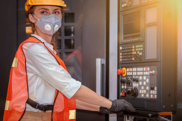 istock Young woman engineer in the mask protected herself with air pollution & virus with controller machine on blurred factory background 1218111484