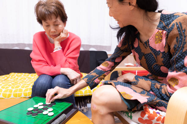 istock Mother and daughter playing board game 1218112587