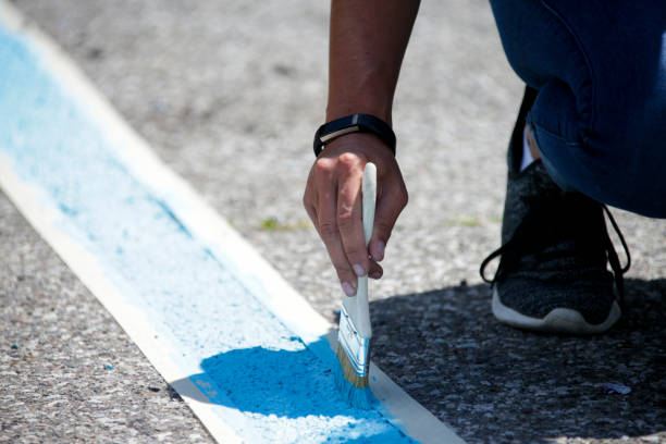Painting blue parking lot lines by hand stock photo
