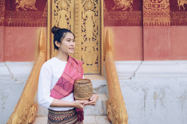 portret azjatki w laotańskim kostiumie i trzymającej drewniany bambus zawierał w środku lepki ryż. - laos luang phabang thailand religion zdjęcia i obrazy z banku zdjęć