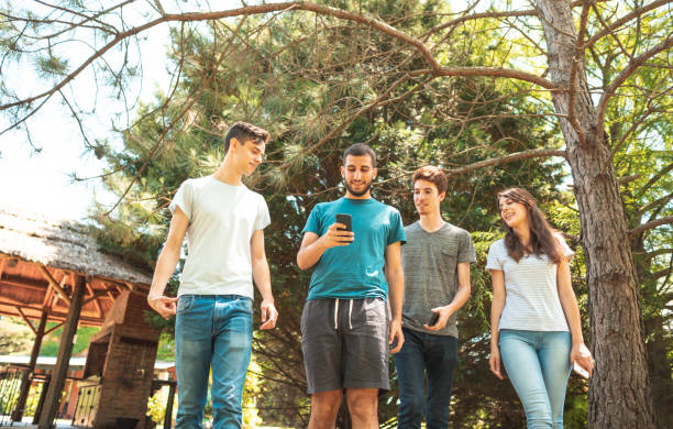 young people walking outdoors and using cell technology - young adult argentinian culture argentinian ethnicity black imagens e fotografias de stock