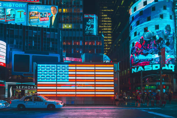 nasdaq stock exchange plakatwand, polizeiauto und amerikanische flagge am times square in new york city - closing ceremony stock-fotos und bilder