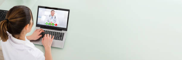 Female Doctor Video Chatting On Laptop