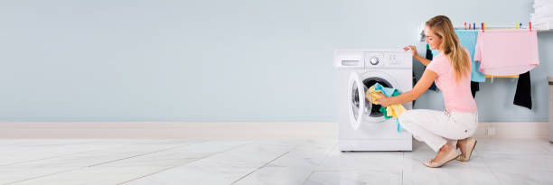 istock Woman Putting Clothes In Washing Machine 1218132179