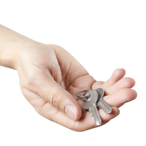 istock Male hand offering house keys on white 1218143126