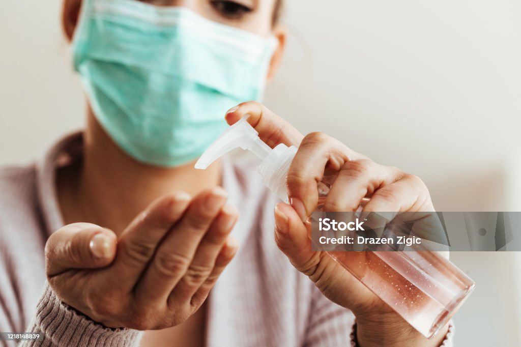 Close-up of woman cleaning her hands with antiseptic hand gel. Close-up of woman using antibacterial hand gel at home. Coronavirus Stock Photo