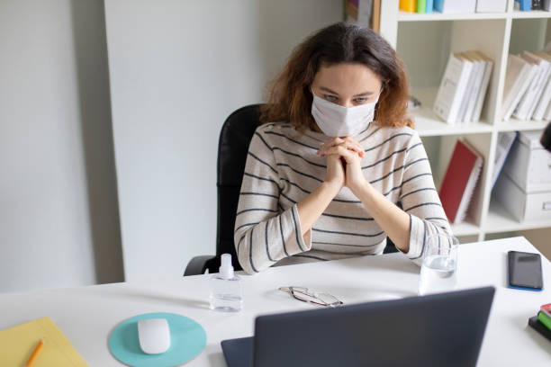 istock Young business woman working from home wearing protective mask 1218152507